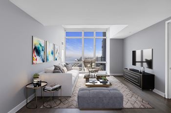 A modern living room with a large window and a grey sofa at SKY Apartments, New York, NY
